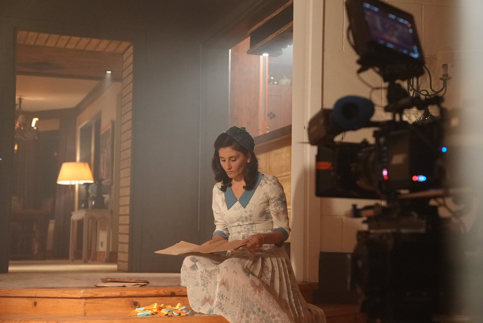 Bir film setinde, sıcak ışık altında mektup okuyan kadın sahnesi