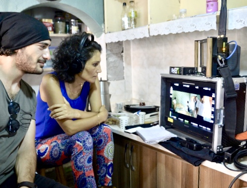 Meta, film setinde kulaklıkla monitörde sahneyi izlerken